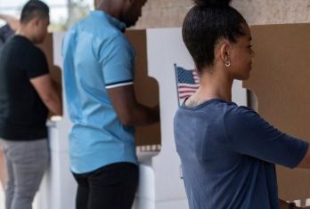 People casting their ballots in voting booths